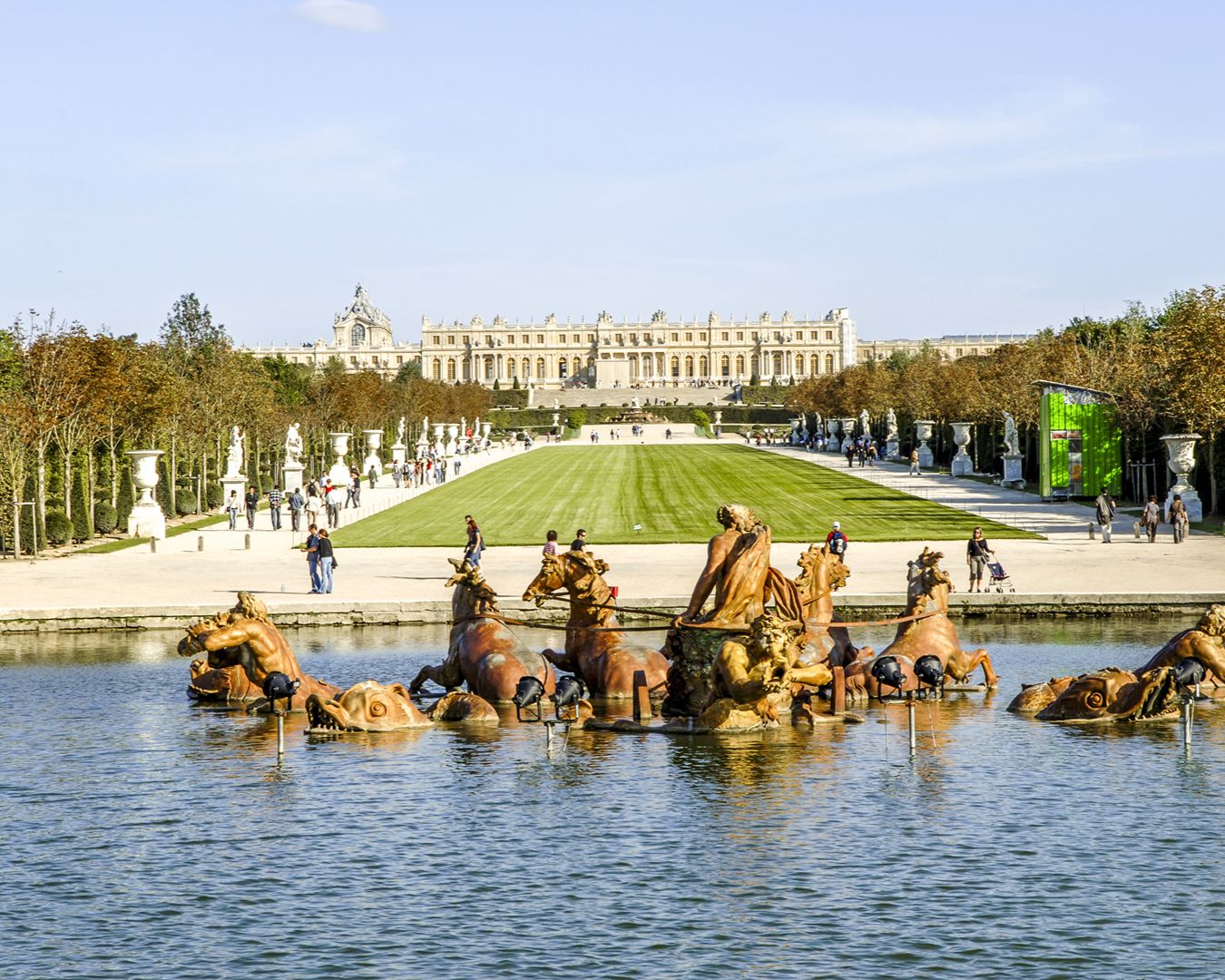 Fonte de Apolo no Palácio de Versalhes com esculturas douradas no lago e o palácio ao fundo