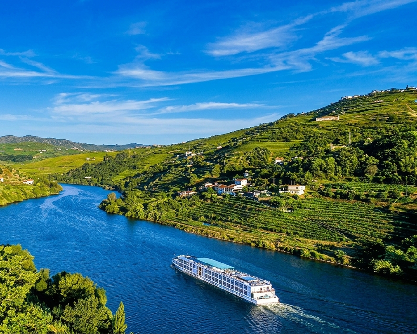 Navio de cruzeiro fluvial navegando pelo Rio Douro entre colinas cobertas por vinhas em socalhos em Portugal.