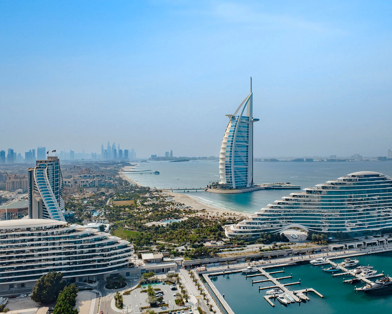 Vista aérea do hotel Burj Al Arab e da orla de Dubai com iates e edifícios modernos