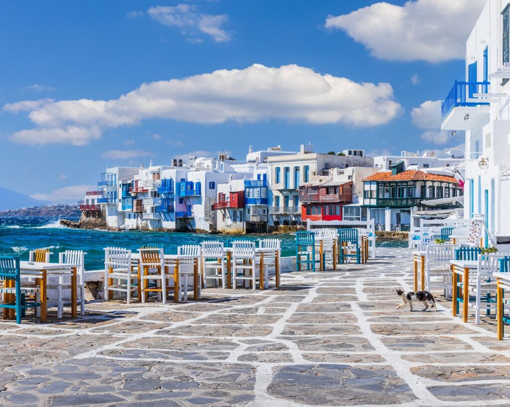 Restaurantes à beira-mar com mesas e cadeiras de madeira na área de Little Venice em Mykonos