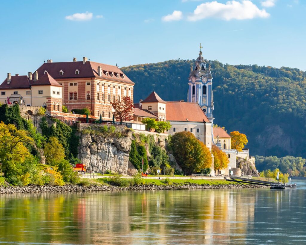 Vila histórica de Dürnstein com a igreja azul refletida no Rio Danúbio