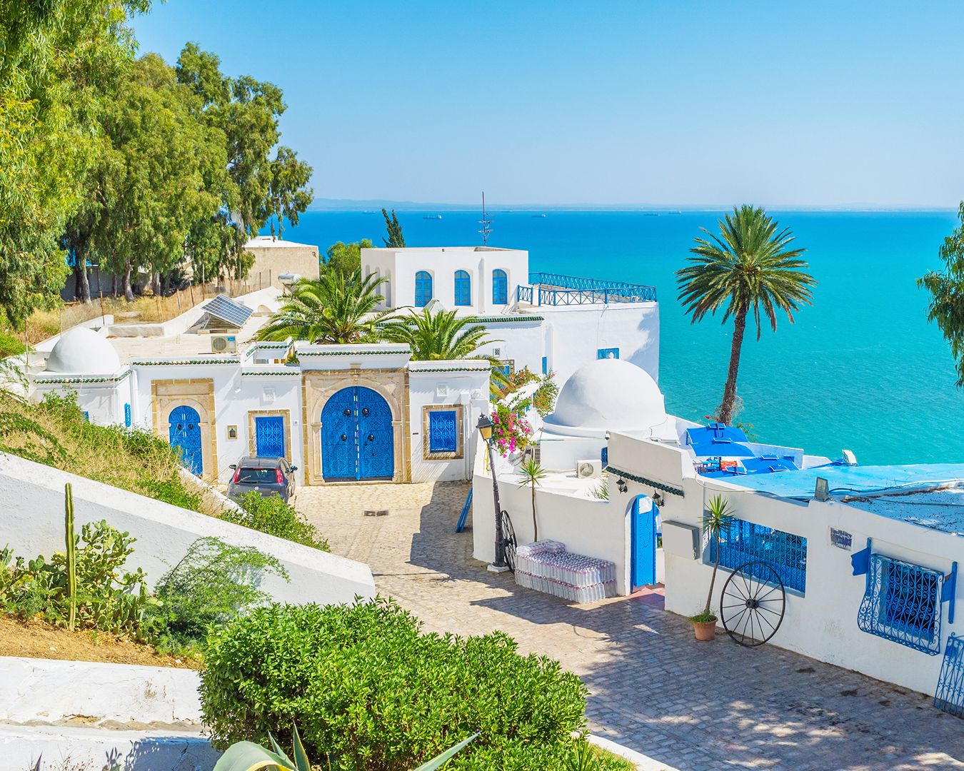 Casarões brancos com portas e janelas azuis no topo de uma colina à beira do Mar Mediterrâneo em Sidi Bou Saïd