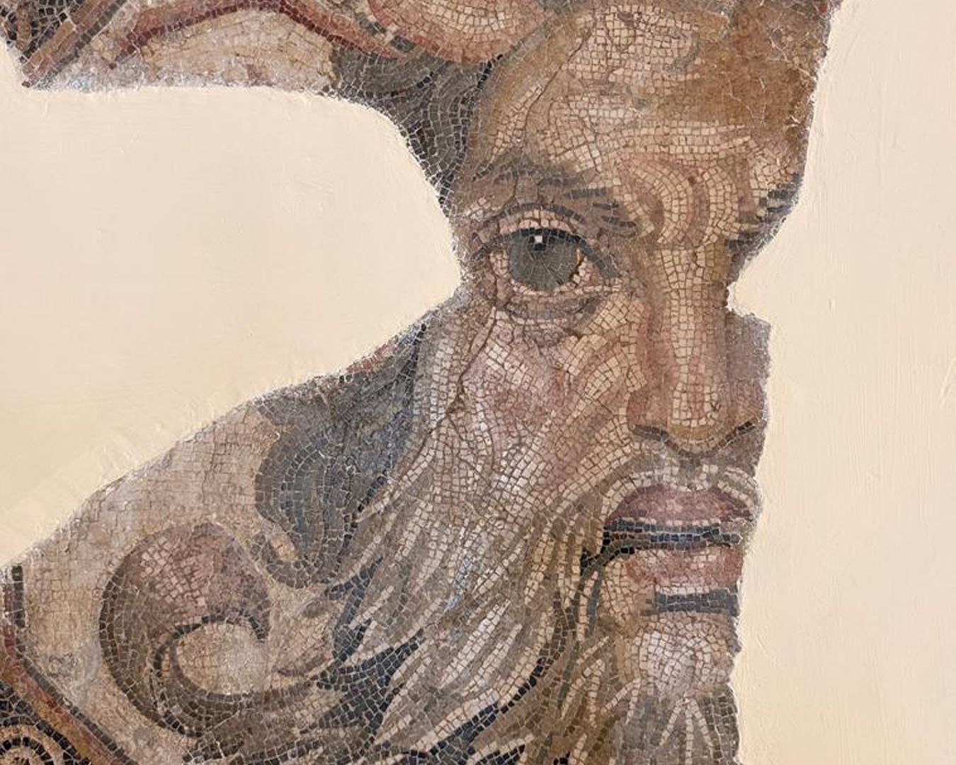 Mosaico romano detalhado retratando a face do deus marinho Oceano com garras de caranguejo na cabeça e barba grisalha